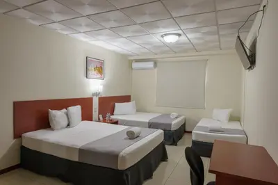 a hotel room with two beds and a table at Hotel Windsor Plaza in San Salvador