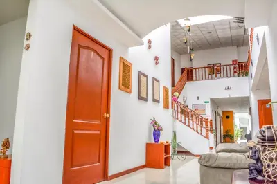 a hallway with a red door and stairs in a house at Hotel Windsor Plaza in San Salvador