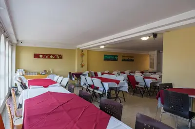 a dining room with red and white tables and chairs at Hotel Windsor Plaza in San Salvador