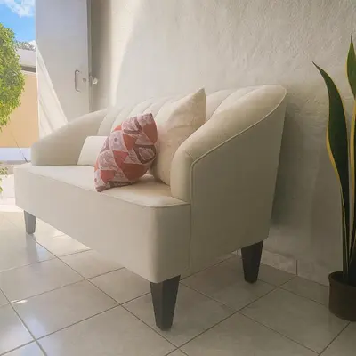 a white couch with two pillows on it in a room at Apto en Santa Ana con AC in Santa Ana