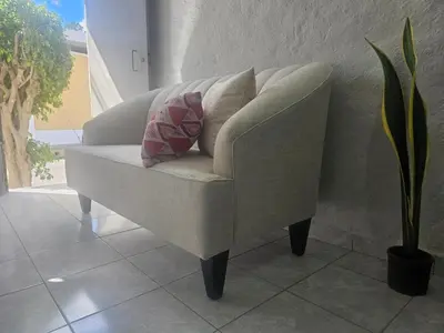 a chair with two pillows on it in a room at Apto en Santa Ana con AC in Santa Ana