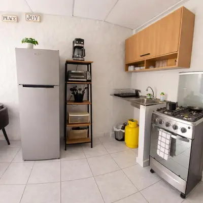 a kitchen with a refrigerator and a stove at Apto en Santa Ana con AC in Santa Ana