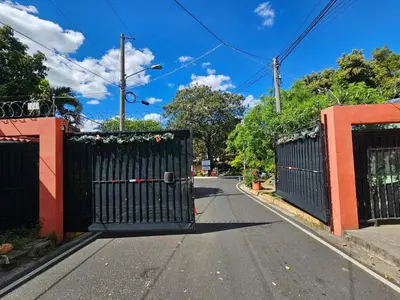 an empty street with a gate on a road at Apto en Santa Ana con AC in Santa Ana