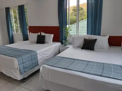 two beds in a room with a window at Jardín Escondido in La Libertad