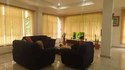 a living room with two couches and a tv at Jardín Escondido in La Libertad