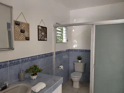 a bathroom with a toilet and a sink and a shower at Jardín Escondido in La Libertad