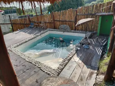 a man swimming in a pool with a swing at Kchimbon rooms best place stay view all Zonte in El Zonte