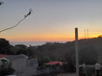 a view of the ocean from a house at sunset at Kchimbon rooms best place stay view all Zonte in El Zonte