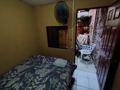 a bedroom with a bed and a chair in a room at Rooms libertad in San Salvador
