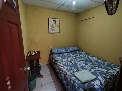 a small bedroom with a bed and a table at Rooms libertad in San Salvador