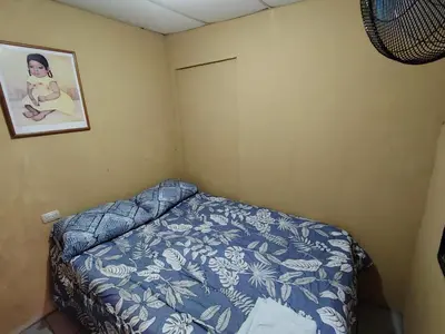 a small bedroom with a bed and a picture on the wall at Rooms libertad in San Salvador
