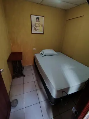a bed in a room with a picture on the wall at Rooms libertad in San Salvador
