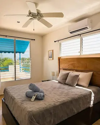 a bedroom with a large bed with a ceiling fan at Casa Cielo in La Libertad