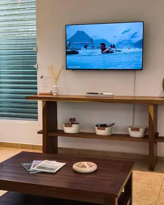 a living room with a flat screen tv on a wall at Casa Cielo in La Libertad