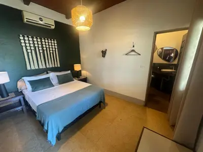 a bedroom with a bed with a blue and white bedspread at Dos Palmas in El Sunzal