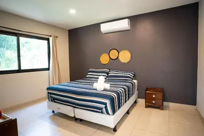 a bedroom with a bed with two mirrors on the wall at Cala los Mangos in Tamanique