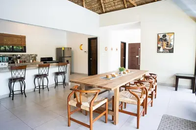 a kitchen and dining room with a wooden table and chairs at Cala los Mangos in Tamanique