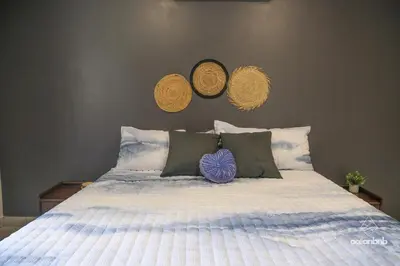 a bedroom with a bed with two baskets on the wall at Cala los Mangos in Tamanique