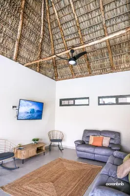 a living room with a couch and a tv at Cala los Mangos in Tamanique