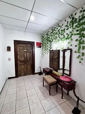 a room with a mirror and a bench and a table at Villa Napoli Apartment Suites in Santa Ana