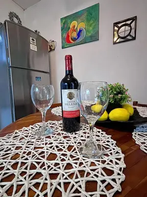 a bottle of wine and two wine glasses on a table at Villa Napoli Apartment Suites in Santa Ana