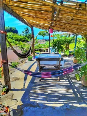 a hammock under a pavilion on a beach at Sea Garden Mizata in Las Piedras