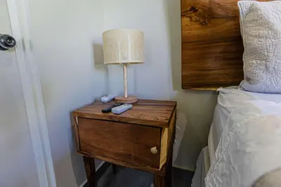 a nightstand with a lamp on it next to a bed at Rancho San Jose - Barra De Santiago in Barra de Santiago