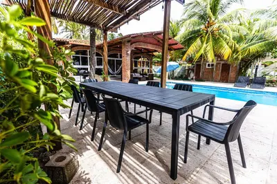 a black table and chairs next to a pool at Rancho San Jose - Barra De Santiago in Barra de Santiago