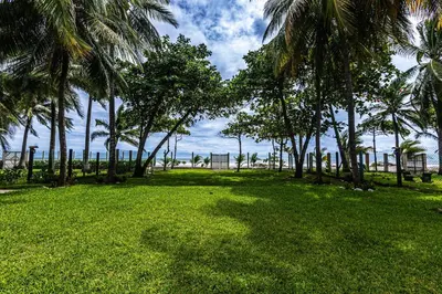 a park with palm trees and a field of grass at Rancho San Jose - Barra De Santiago in Barra de Santiago