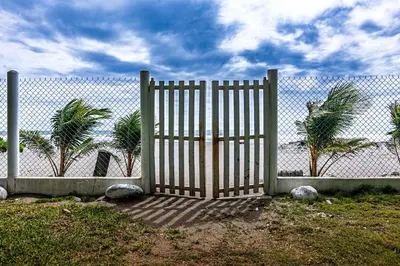 a gate in front of a fence with palm trees at Rancho San Jose - Barra De Santiago in Barra de Santiago