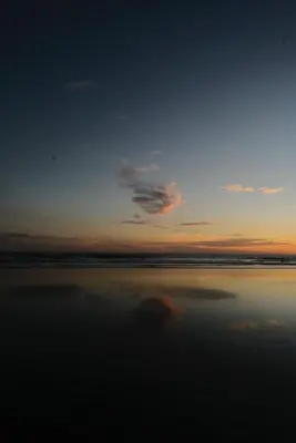 a sunset on the beach with the sky and the water at Casa Origen El Zonte in El Zonte