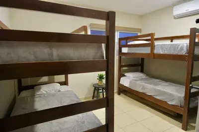 a room with three bunk beds and a window at Casa Origen El Zonte in El Zonte