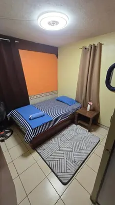 a room with two beds and a rug at KR apartment CENTRO HISTÓRICO, SAN SALVADOR, TRES HABITACIONES 4 CAMAS parking wifi netflix VIX y mas in San Salvador