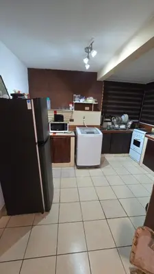 a kitchen with a black refrigerator and a tile floor at KR apartment CENTRO HISTÓRICO, SAN SALVADOR, TRES HABITACIONES 4 CAMAS parking wifi netflix VIX y mas in San Salvador