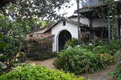 a white house with a porch and a balcony at Hostal y Restaurante Chilltepe Ataco in Concepción de Ataco