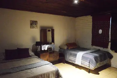 a bedroom with two beds and a mirror at Hostal y Restaurante Chilltepe Ataco in Concepción de Ataco