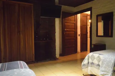 a room with two beds and an open door at Hostal y Restaurante Chilltepe Ataco in Concepción de Ataco