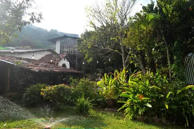 a view of a garden with a house in the background at Hostal y Restaurante Chilltepe Ataco in Concepción de Ataco