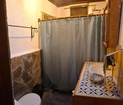 a bathroom with a shower curtain and a sink at Hostal y Restaurante Chilltepe Ataco in Concepción de Ataco