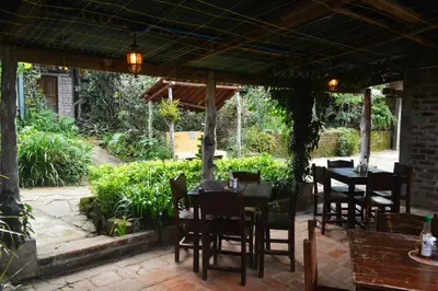 a restaurant with tables and chairs under a pavilion at Hostal y Restaurante Chilltepe Ataco in Concepción de Ataco