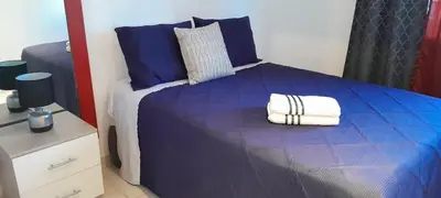 a bedroom with a blue bed with towels on it at Flamingo loft in La Puerta de La Laguna