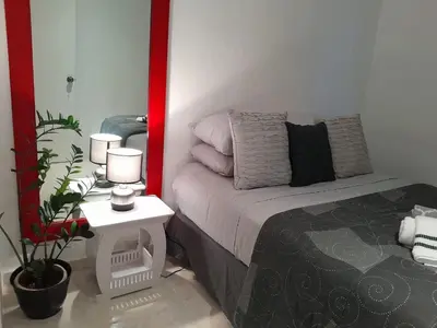 a bedroom with a bed and a table with two lamps at Flamingo loft in La Puerta de La Laguna