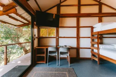 a room with two bunk beds and a desk and a tv at Punta Mango Villas in La Periquera