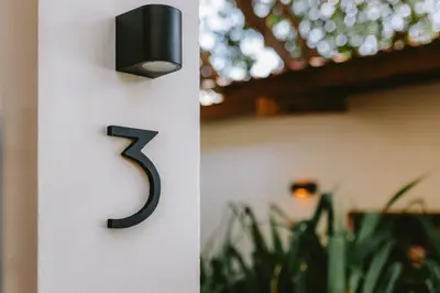 a black number on a white wall with plants at Punta Mango Villas in La Periquera