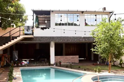 a house with a swimming pool in front of a building at The Salty Dogs in Playa San Blas