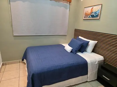 a bedroom with a bed with blue sheets and pillows at Confort en La Unión in La Unión