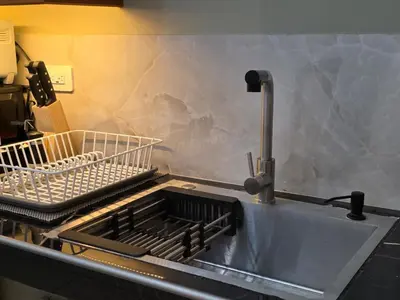 a kitchen sink with two drying racks on it at Confort en La Unión in La Unión