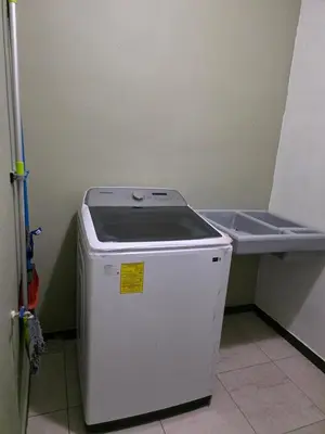 a small white refrigerator in a room with a shelf at Confort en La Unión in La Unión