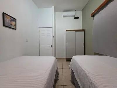 a bedroom with two beds and a door to a room at Confort en La Unión in La Unión