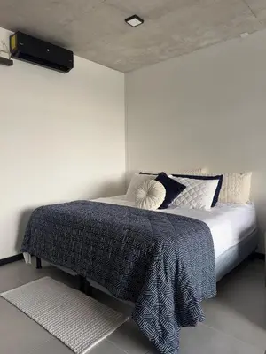 a bedroom with a bed with a tv on the wall at Beko San Benito in San Salvador